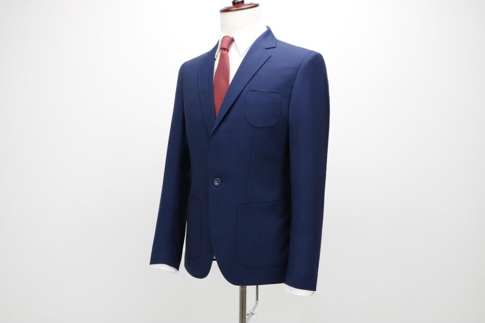 A navy suit jacket with a white shirt and red tie on a stand