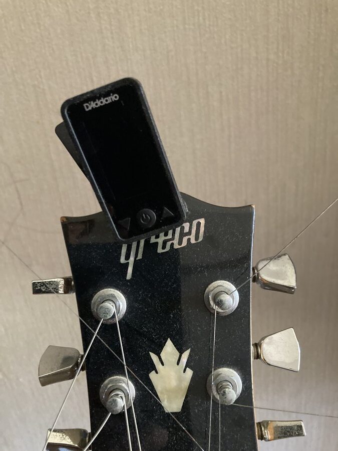 A clip-on tuner on the headstock of another guitar