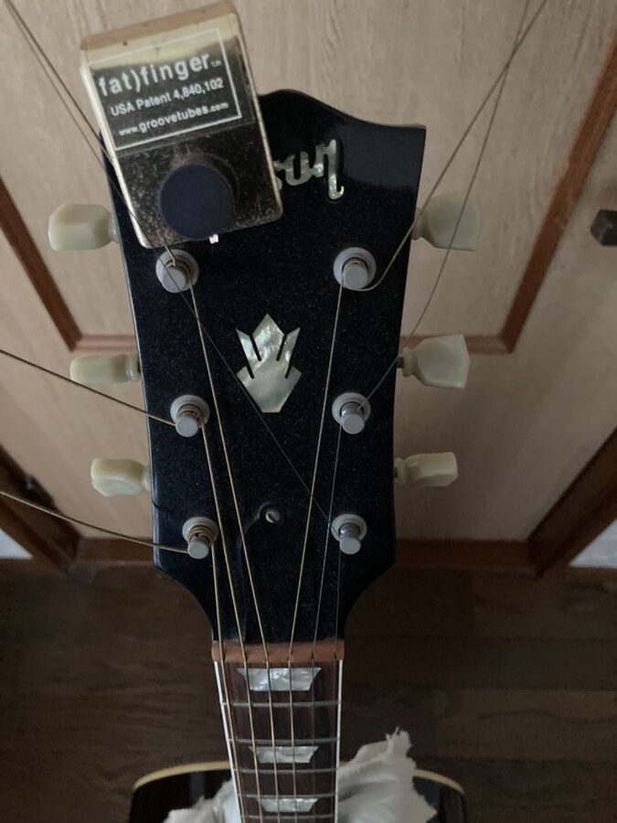 A fat finger weight clamped on the headstock of the guitar